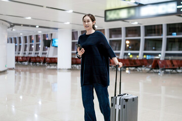 Fototapeta premium Modern Traveler at Airport with Luggage and Smartphone