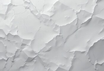 Obraz premium A weathered white wall displaying a network of cracks and scratches, revealing its age and history. The surface texture adds character, with subtle shadows enhancing the imperfections.