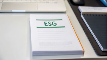 ESG document on a desk with office supplies nearby.