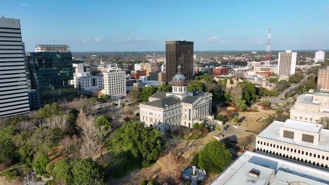 Push-in aerial footage rotating around the SC statehouse with Columbia, SC in the background.
