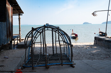 A peaceful beach view with a wooden bench by the ocean, sunset over the water, and a boat on the...