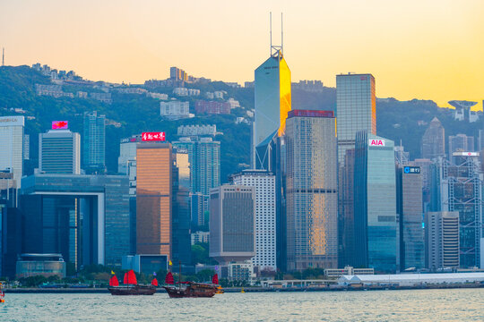 City urban and and sailing sailboats evening sunset view of tall glass skyscrapers in the financial district building, a symbol of the region's economic development. China, Hong Kong, 20 March 2025