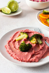 A nutritious morning meal featuring sweet potato, broccoli, radish salad with chia seeds and beet hummus for a balanced, protein-packed start
