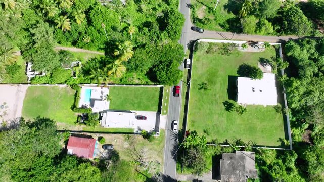 Aerial footage of cars travelling down PR 681, through the community of Islote.