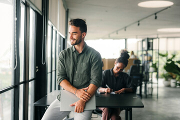 Portrait of a handsome successful young business people, software engineer with laptop in the office