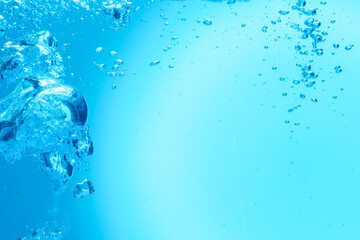 Many water bubbles on light blue background, closeup. Space for text