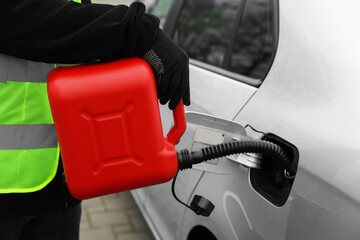 Man with canister refueling car outdoors, closeup