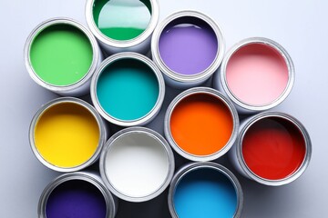 Cans of bright paints on grey background, flat lay