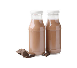 Tasty chocolate milk in glass bottles and pieces of chocolate isolated on white