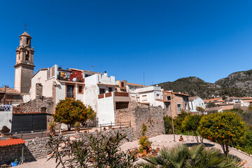 a view of a town with a church and mountains in the background .La vall de gallinera, Alicante, Spain