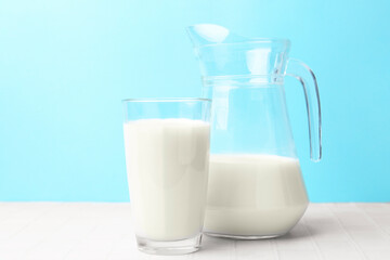 Fresh milk on white table against light blue background