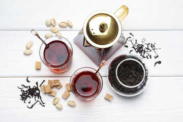 Tasty Turkish tea, sugar and pistachios on white wooden table, flat lay