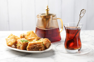 Tasty Turkish tea served with baklava on white marble table