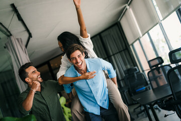 Overjoyed young multiethnic colleagues celebrating shared corporate success or goal achievement