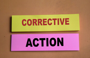 Concept of Corrective Action write on sticky notes isolated on Wooden Table.