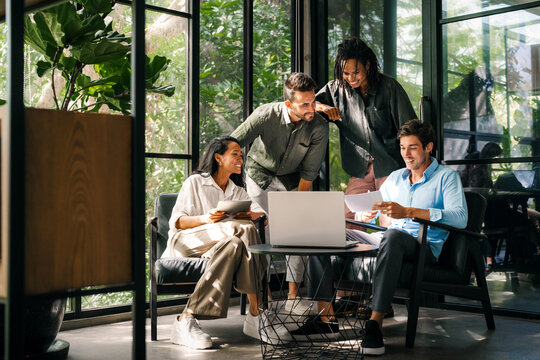Multicultural professional businesspeople working together on research plan in boardroom.