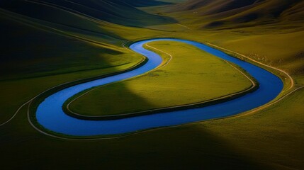 An aerial shot of a winding blue river through green fields