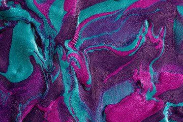 Vibrant metallic paints swirling in abstract pattern