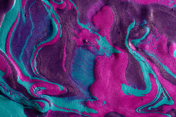Vibrant metallic paint swirls in blue and magenta