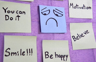 Sticky notes with motivational messages around a sticky note with a sad face.
