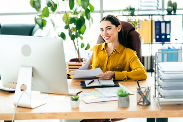 Confident Young Businesswoman Working Productively in a Stylish Office Environment with Natural...