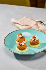 Artful Presentation of Fish Croquettes on Creamy Mashed Potatoes with Vibrant Lighting and Earthy Palette