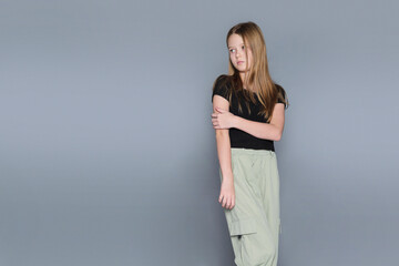 A girl poses gently, with a distant gaze against a simple background. Realistic photography like...