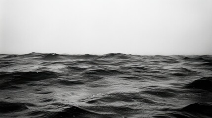 A dark and textured ocean surface under a gray sky