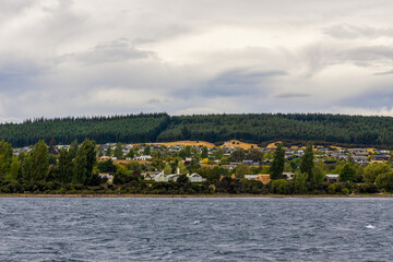 Lake Wanaka, a summer cloudy afternoon with a mountain range and the town of Wanaka on the shore. South Island, New Zealand