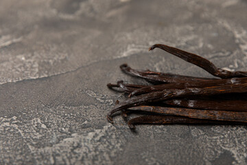 Vanilla pods on a textured background. Vanilla flowers and seeds. vanilla stick bean. Aromatic spicy spice for pastries and desserts. Seasoning. Space for text. Copy Space
