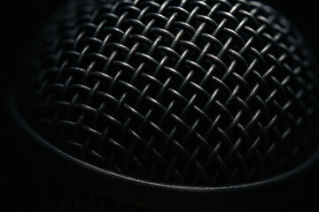 The Microphone: A detailed shot of the microphone net in low light setting, its mesh, texture, design and appearance in high details