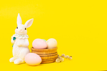 Easter bunny with painted eggs on color background