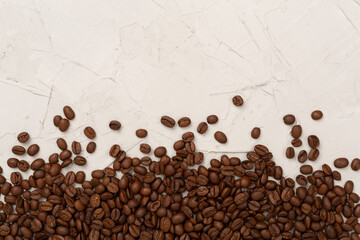 Roasted coffee beans with leaves on concrete background,top view