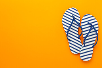 Striped blue flip flops on color background, top view