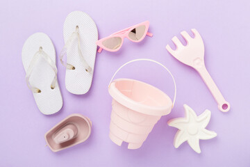Children's flip flops and beach toys on color background,,top view