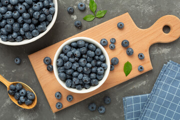 Bowl with fresh bright blueberries on concrete background,top view