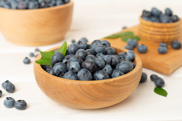 Bowl with fresh blueberries on wooden table