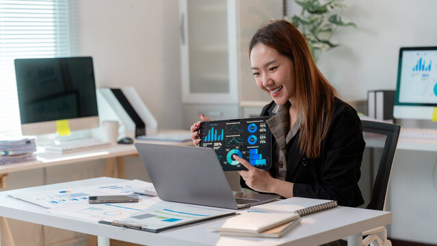 Asian businesswoman showing infographic on tablet during video call meeting - Powered by Adobe