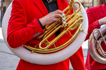 musician dressed in a red jacket, playing a wind instrument – ​​the main element is a...