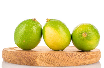 Several juicy limes with wooden tray isolated on white background, close-up.