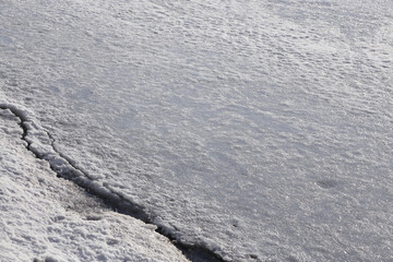 A large crack in the ice, melting ice in spring.