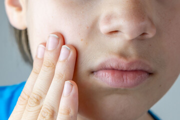 Young male teen examines pimple in mirror, highlighting self-image issues and teenage skin concerns