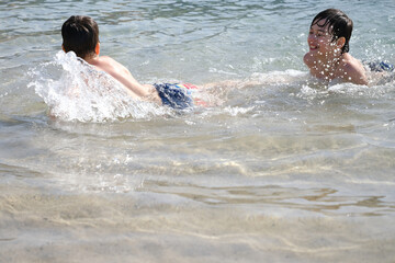 two cheerful teenagers, boys swimming in sea, ocean waves, Summer fun beach, family Water...