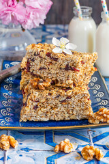 Homemade breakfast bars made of rolled oats, nuts, dried cranberries and honey