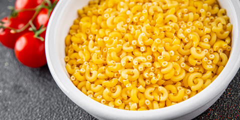 Macaroni pasta raw coquillette appetizer dish organic product fresh tasty gourmet food background on the table rustic food top view copy space