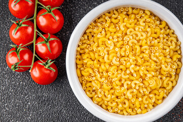 Macaroni pasta raw coquillette appetizer dish organic product fresh tasty gourmet food background on the table rustic food top view copy space