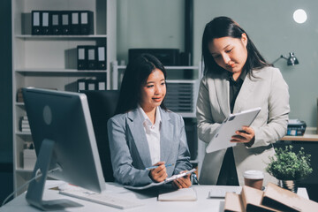 Asian Businesswoman Using laptop computer and working at office with calculator document on desk, doing planning analyzing the financial report, business plan investment, finance analysis concept.