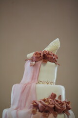 Elegant three-tier wedding cake with decorative roses and shoe topper