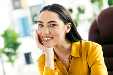 Smiling young businesswoman with natural beauty in modern office environment showcasing confidence...