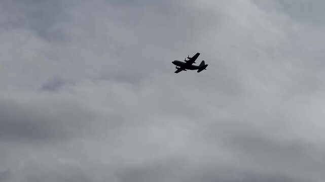 lockheed c-130 transport aircraft flying in cloudy sky